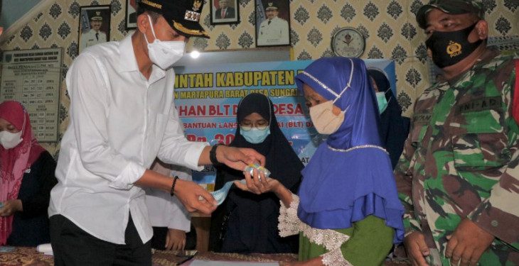 Bupati Banjar Saidi Mansyur menyerahkan Bantuan Langsung Tunai(BLT) dana desa kepada salah satu perwakilan Keluarga Penerima Manfaat (KPM) di Desa Sungai Batang Ilir. Foto humas/Antaranews Kalsel