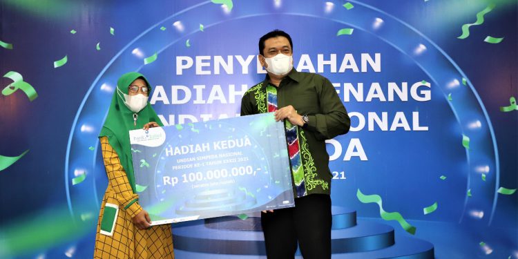 Penyerahan secara simbolis oleh Plt. Direktur Utama Bank Kalsel, I G.K Prasetya kepada Nor Alimah, pemenang undian Rp 100 juta.