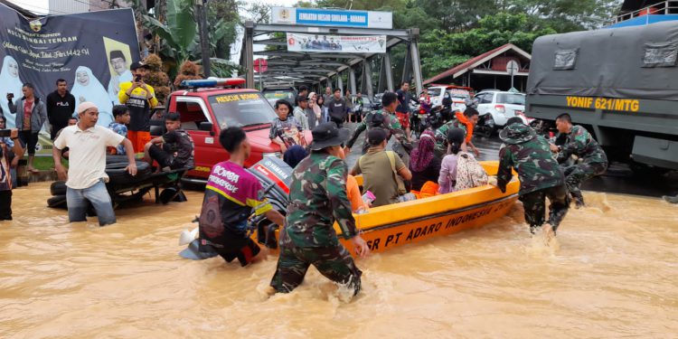 Prajurit Korem 101/Antasari saat mengevakuasi warga korban banjir dengan perahu karet.