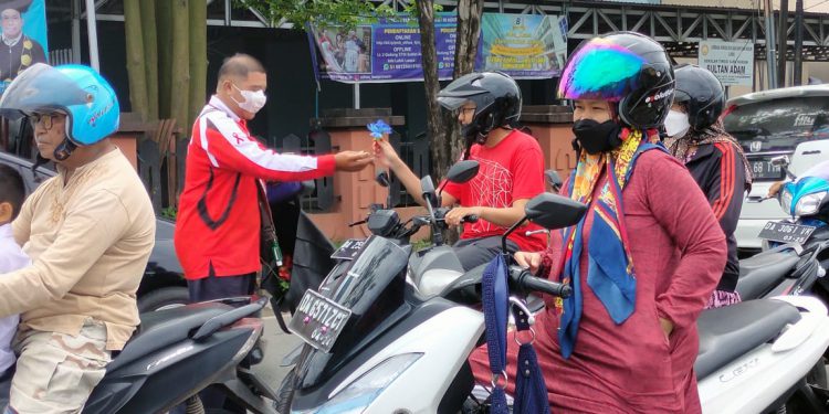 Aktivis HIV/AIDS Kalsel Gatot Noor Saputra seorang diri membagikan bunga mawar dan pita red ribbon dalam rangka memperingati Hari AIDS Sedunia.