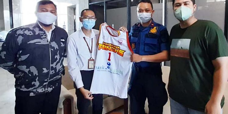 Ketua Tim Basket Mahadaya Feniks Maulana Fathaillah, secara simbolis menyerahkan jersey Tim Basket Mahadaya Feniks kepada Manager Keberlanjutan Perusahaan Divisi Corporate Secretary Bank Kalsel Shah Rizky Kurniawan.