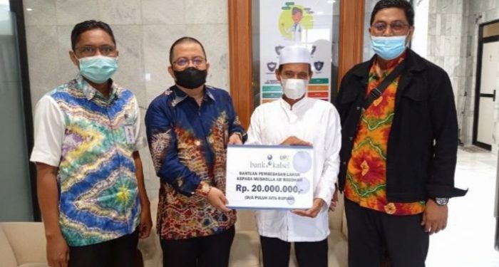 Direktur UPZ Bank Kalsel, Fajri Muhtadi secara simbolis serahkan bantuan kepada Madri, panitia pembangunan Musholla Ar-Raudhah. (Foto : Bank Kalsel)