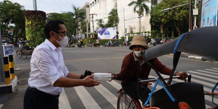 Jajaran Bank Kalsel saat membagikan takjil kepada paman Becak. (foto : Bank Kalsel).