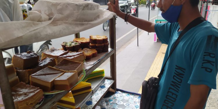 Faisal pedagang kue, salah satunya bingka, di kawasan jalan H Hsasan Basry Banjarmasin. (foto : shn)