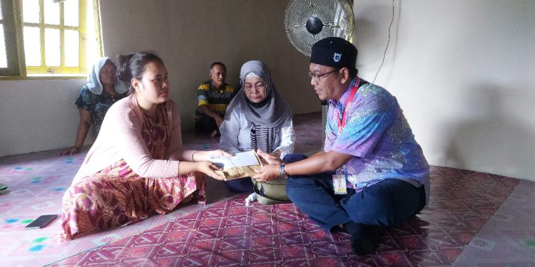 Pihak Alfamart saat mengunjungi rumah korban sekaligus menyerahkan santunan . (foto : istimewa)