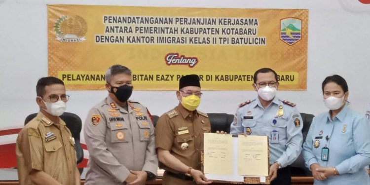 Foto bersama pihak Kanwil Kemenkumham Kalsel dan Pemkab Kotabaru sambil menunjukkan dokumen PKS layanan eazy pasport. (foto : Humas Kemenkumham Kalsel)