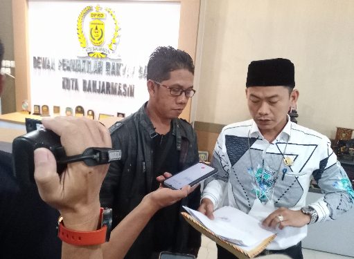 Ketua RW 1 Kelurahan Kuin Cerucuk Ahmad Husain saat menyerahkan surat keluhan warga kepada Wakil Ketua DPRD Banjarmasin HM Yamin. (foto : smr)