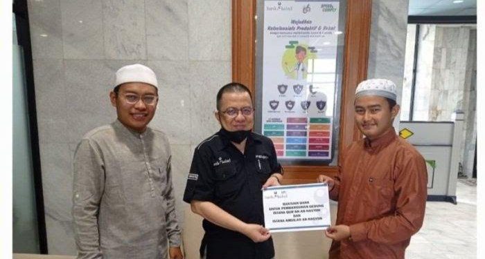 Penyerahan bantuan dilakukan secara simbolis oleh Direktur UPZ Bank Kalsel, H. M. Fajri Muhtadi kepada Ustadz M Noor di Kantor Pusat Bank Kalsel. (foto : Humas Bank Kalsel)