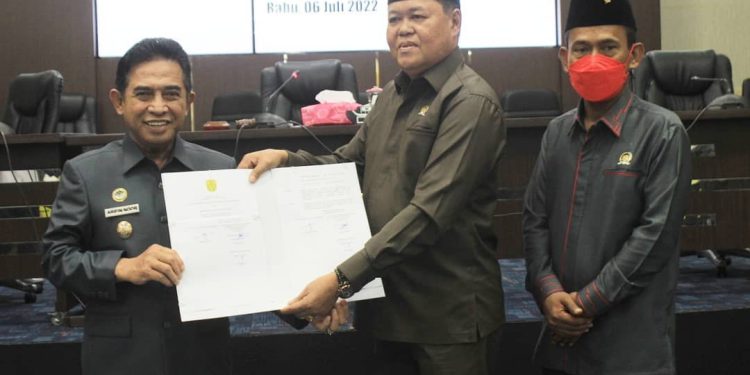 Wakil Ketua DPRD Banjarmasin Matnor Ali menyerahkan Perda Persetujuan LPJ APBD 2021 kepada Wakil Walikota Banjarmasin H Arifin Noor. (foto : smr)