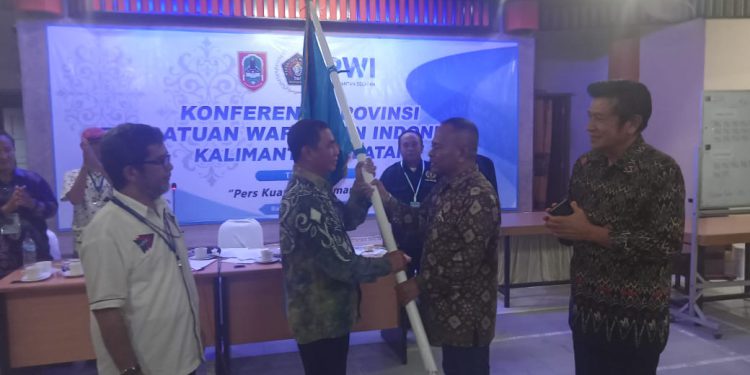 Ketua PWI Kalsel terpilih Zainal Helmie saat menerima kembali bendera pataka PWI Kalsel dari Ketua PWI Pusat Atal S Depari. (foto : smr)