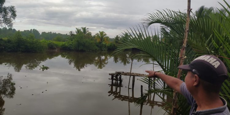 Warga saat menunjuk lokasi kemunculan buaya di sungai Tatah Bangkal. (foto : shn)