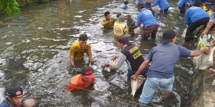 Peserta lomba saat berlomba mengangkut lumpur di Sungai Veteran. (foto : shn)