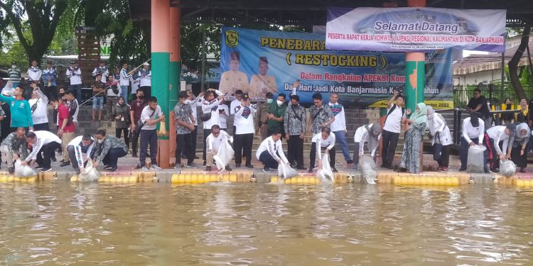 Peserta Rakerwil Apeksi Komwil V tebar benih ikan di Sungai Martapura, Banjarmasin. (foto : shn)