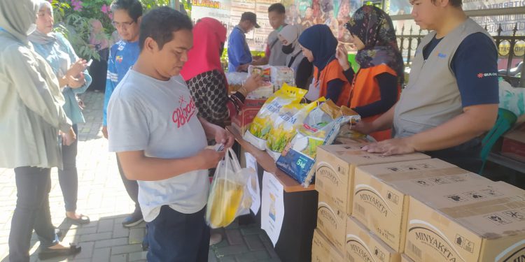 Warga saat membeli kebutuhan pokok di Pasar Murah yang digelar di halaman Kantor Kelurahan Basirih Selatan. (foto : shn)