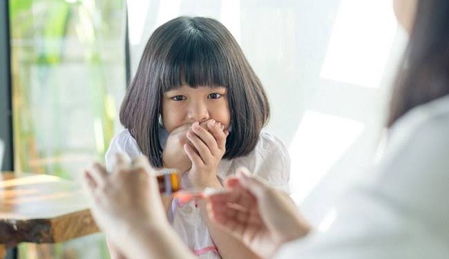 Ilustrasi orang tua saat berikan obat sirup ke anak.