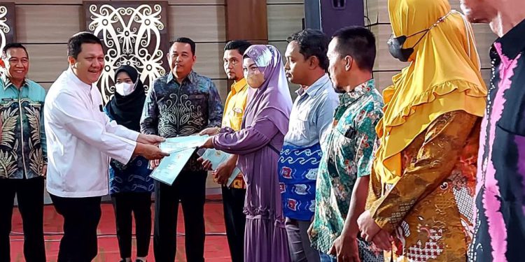 Anggota Fraksi Gerindra DPR RI Difriadi Darjat menyerahkan sertifikat secara simbolik kepada sejumlah warga Banjarmasin. (foto : smr)