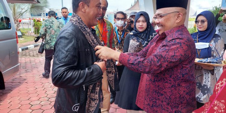 Ketum Korpri Zudan Arif Fakhrullah disambut secara adat oleh Sekdaprov Sumbar sebagai sahibul bait dengan memasangkan "Deta" penutup kepala khas Minang lengkap dengan selempang buatan Tanah Liek. (foto : istimewa)