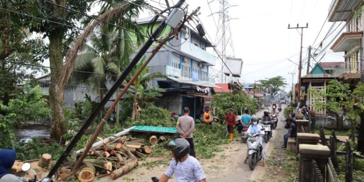 Warga dan relawan bersama personel BPBD Banjarmasin saat membersihkan pohon tumbang di kawasan Komplek Agraria 3, Banjarmasin. (foto : shn)