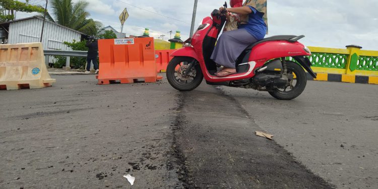 Oprit jembatan Gerilya yang terjadi penurunan diperbaiki dengan cara ditambal aspal. (foto : shn)