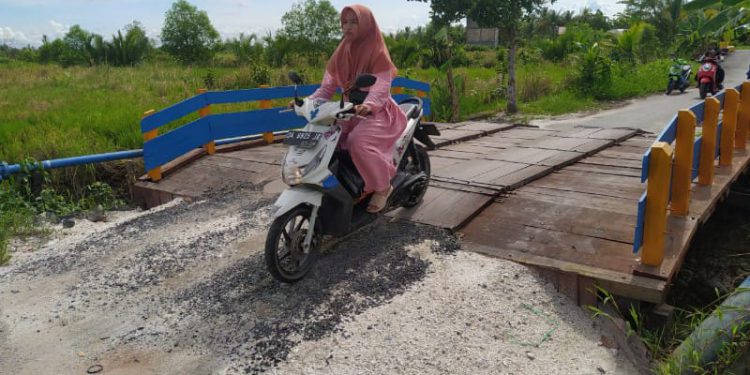 Warga saat melintasi jembatan yang sudah direnovasi. (foto : shn)