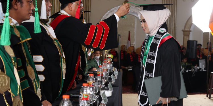 Rektor UNBL Dr HM Muslim memindahkan tali toga dalam prosesi wisuda angkatan ke - 1 UNBL. (foto : istimewa)