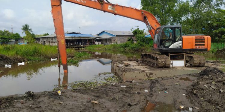 Alat berat eksavator saat melakukan pengerukan sungai. (foto : shn)