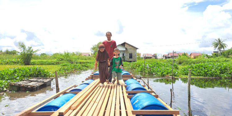 Zainal beserta anak saat mencoba jembatan apung bantuan Bank Kalsel.