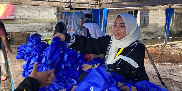 Pihak Bank Kalsel bagikan paket makanan saat Haul Ke-18 Guru Sekumpul di Kampung Keramat, Martapura Timur. (foto : istimewa/Bank Kalsel)