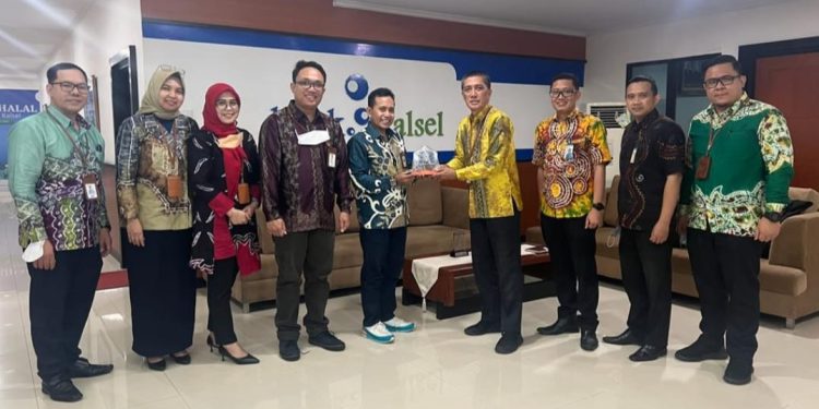 Direktur Bisnis Bank Kalsel Fachrudin menyerahkan plakat kenang-kenangan usai menerima kunjungan rombongan Bank Kalbar. (foto : istimewa)