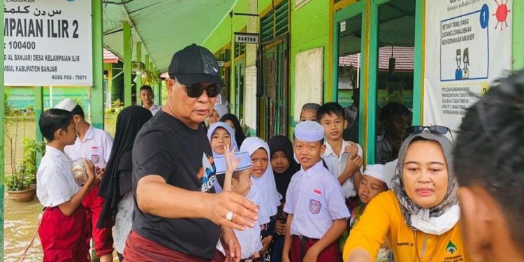 Gubernur Kalsel H Sahbirin Noor atau disapa Paman Birin mengunjungi SDN Kelampaian Ilir 2 yang terdampak banjir dan membagikan nasi bungkus kepada para pelajar dan guru. (foto : istimewa)