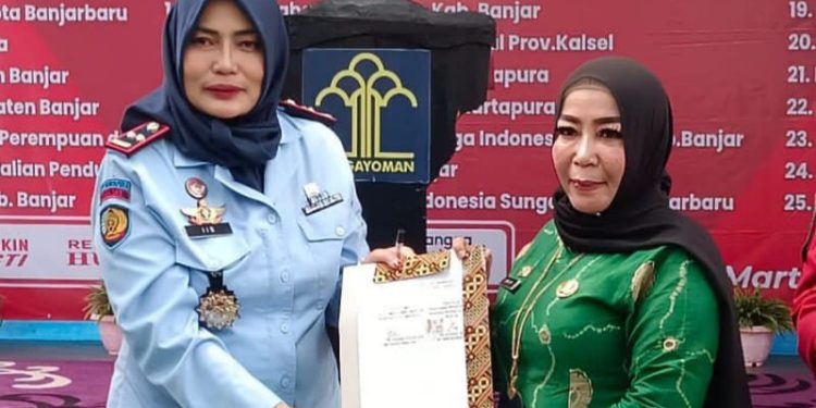 Kepala Dispersip Kalsel Hj. Nurliani Dardie bersama pihak Lapas Martapura saat menunjukkan dokumen kerja sama minat baca. (foto : istimewa/Dispersip Kalsel)