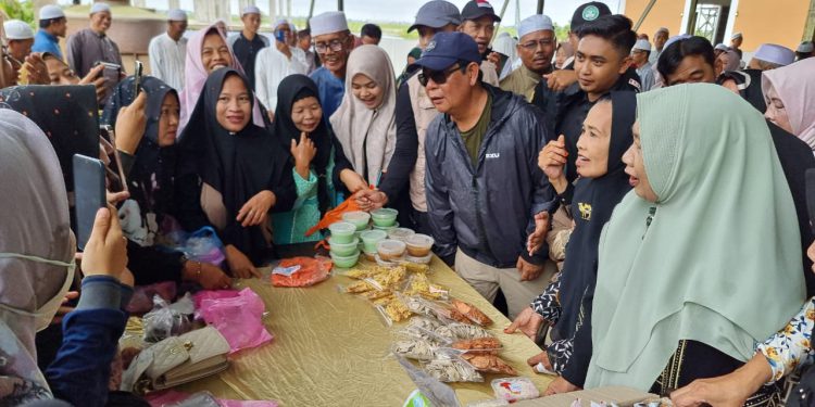 Gubernur Kalsel H Sahbirin Noor atau Paman Birin saat ikut menawarkan jualan di Saprah Amal Ponpes Nurul Sholihin. (foto : istimewa)