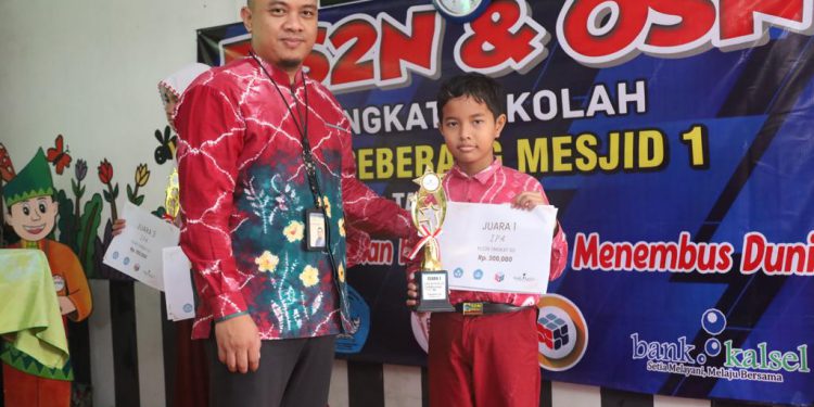 Assisten Manager Corporate & Marketing Communication Divisi Sekretaris Perusahaan Septian Reiswandy menyerahkan hadiah dan tropi kepada salah satu pemenang lomba. (foto : istimewa/Bank Kalsel)