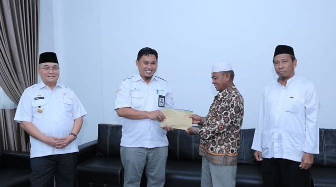 Penyerahan bantuan secara simbolis oleh Pimpinan Bank Kalsel Syariah Cabang Kandangan Viktor, R.M kepada penerima disaksikan Bupati HSS Achmad Fikry.