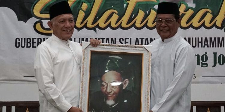 Gubernur Kalsel H Sahbirin Noor atau Paman Birin mendapatkan kenang-kenangan dari Gus Kikin berupa foto ulama besar Kiai Haji Muhammad Hasyim Asy’ari yang merupakan pahlawan nasional dan merupakan pendiri NU. (foto : istimewa)