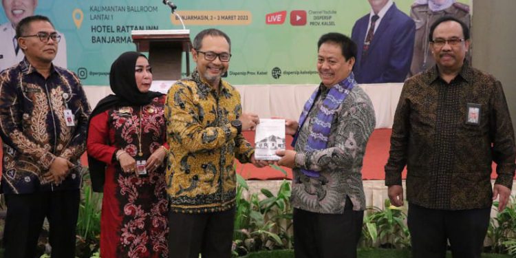 Penyerahan buku oleh Kepala Perpusnas RI Muhammad Syarif Bando kepada perwakilan BI Kalsel pada Rakor Perpustakaan yang digelar Dispersip Kalsel. (foto : istimewa/Humas BI Kalsel)