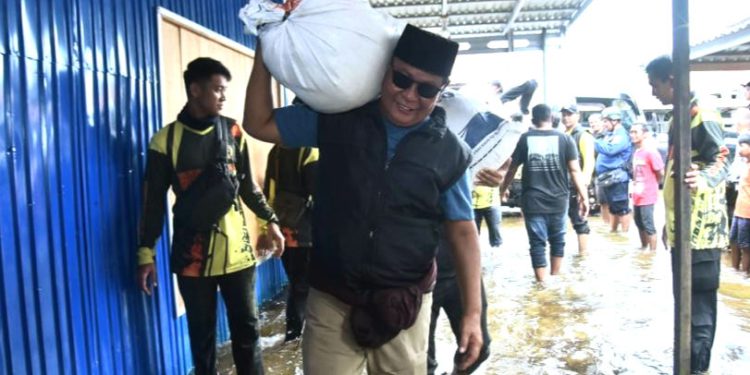 Gubernur Kalsel H Sahbirin Noor atau Paman Birin pikul bantuan beras untuk diantar langsung ke warga terdampak banjir. (foto : istimewa/Pemprov Kalsel)