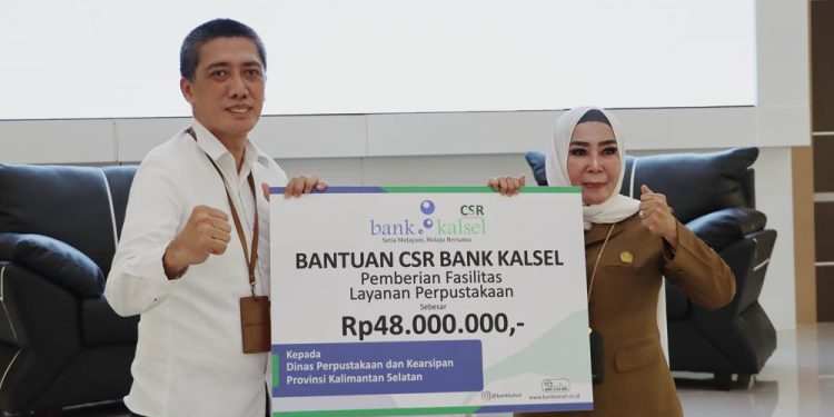 Secara simbolis bantuan diserahkan Plt. Dirut Bank Kalsel Fachrudin, kepada Kepala Dispersip Kalsel, Hj. Nurliani Dardie atau akrab disapa Bunda Nunung. (foto : istimewa/Bank Kalsel)