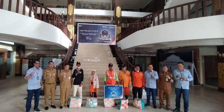 Walikota Banjarmasin H Ibnu Sina berfoto bersama pihak BNI dan petugas kebersihan yang menerima paket sembako. (foto : shn/seputaran)