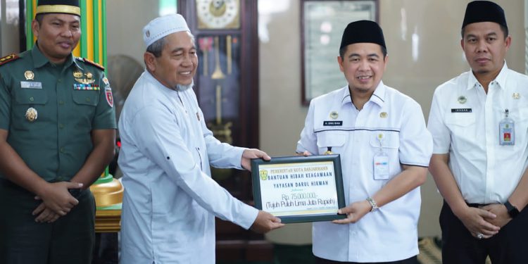 Walikota Banjarmasin H Ibnu Sina saat menyerahkan bantuan secara simbolis kepada perwakilan Mesjid Darul Hikmah. (foto : istimewa/Pemko Banjarmasin)