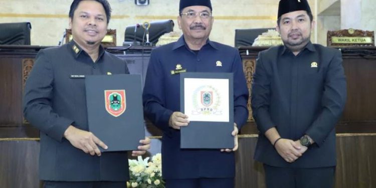 Ketua DPRD Kalsel H Supian HK bersama Sekdaprov Kalsel Roy Rizali Anwar saat menunjukan dokumen Perda Pembangunan Perkebunan yang disahkan. (foto : smr/seputaran)