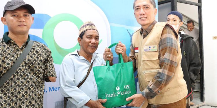 Plt Dirut Bank Kalsel Fachrudin menyerahkan paket bantuan kepada perwakilan komunitas Semangat Komunitas Berkarya. (foto : istimewa/Bank Kalsel)