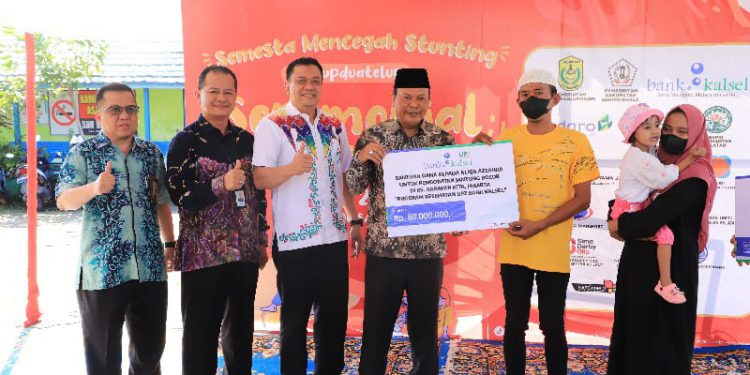 Bantuan secara simbolis diserahkan Pj. Bupati Batola H Mujiyat didampingi Direktur Kepatuhan, IGK Prasetya, Direktur UPZ Bank Kalsel M. Fajri Muhtadi dan Kepala Divisi Sekretaris Perusahaan Suriadi kepada Aliqa Az-Zahra. (foto : istimewa)