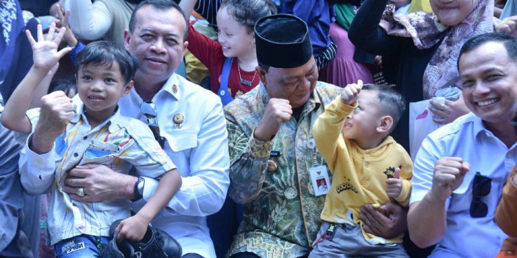 Gubernur Kalsel H Sahbirin Noor atau Paman Birin saat memangku seorang balita saat kunjungan di Posyandu Sakura. (foto : istimewa)