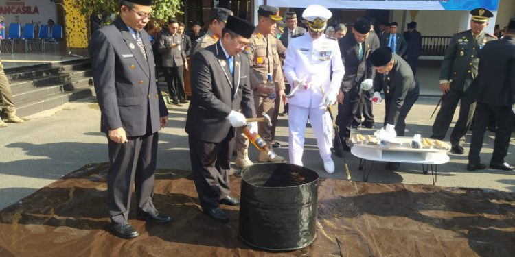 Walikota Banjarmasin H Ibnu Sina pecahkan botol Miras pada pemusnahan barang bukti hasil operasi Satpol PP Banjarmasin. (foto : shn/seputaran)