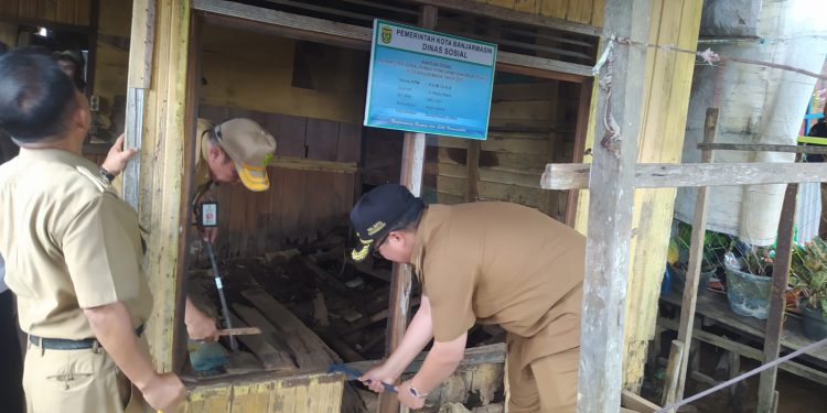 Walikota Banjarmasin H Ibnu Sina saat ikut membongkar rumah warga yang mendapat bantuan program RS Rutilahu. (foto : shn/seputaran)