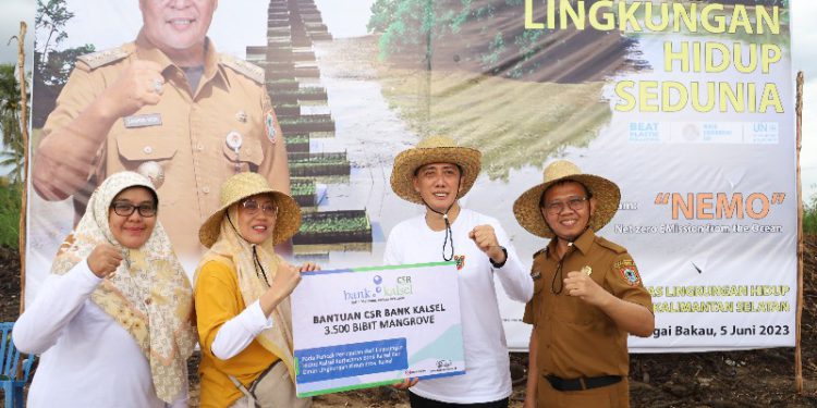 Secara simbolis bantuan bibit Mangrove diserahkan Plt Dirut Bank Kalsel Fachrudin kepada Kepala DLH Kalsel Hanifah Dwi Nirwana. (foto : istimewa/Bank Kalsel)