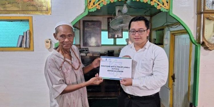 Staf UPZ Bank Kalsel saat menyerahkan bantuan kepada Wajiman. (foto : istimewa)