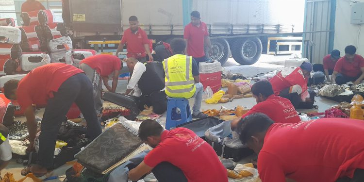 Proses pengecekan dan pembongkaran air Zamzam yang ditemukan dalam koper jemaah. (foto : istimewa)