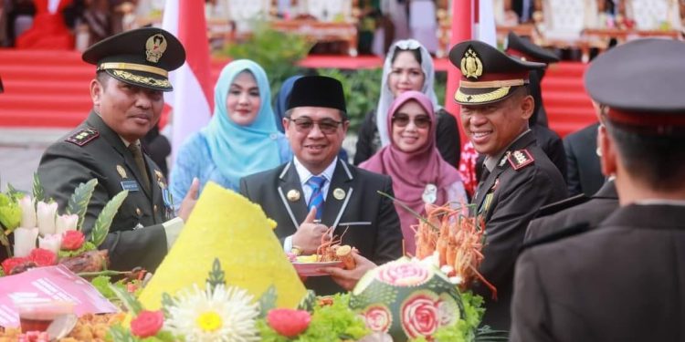 Walikota Banjarmasin H Ibnu Sina dan Kapolresta Banjarmasin Kombes P Sabana A Martosumito saat potong tumpeng pada HUT Bhayangkara ke-77 di Halaman Balaikota Banjarmasin. (foto : shn/seputaran)